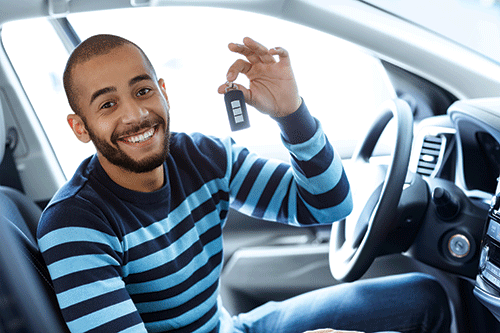 happy young guy buying a car